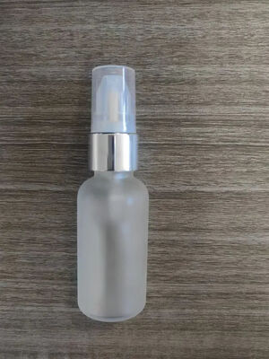 Botella de vidrio colorida con bomba de crema