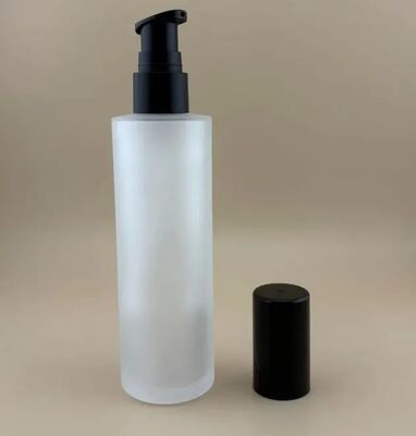 Botella de vidrio transparente mate con bomba de tratamiento negra para cosméticos